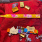 Valentine’s gift set featuring colorful Pop It fidget toys, laser-engraved wooden tags with festive messages, and decorative chocolates, arranged on a red fabric backdrop.