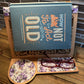 Handcrafted wooden book stand with a laser-cut design, holding a sample book featuring a purple floral pattern on the base and glasses resting on the side.