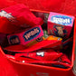 A close-up of a red mini tin mailbox personalized with the assorted non-chocolates inside the mailbox highlighting the mailbox as a customizable Valentine’s Day gift.