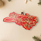 Red North Carolina dogwood ornament on a cream background with holiday decorations