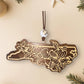 Walnut North Carolina dogwood ornament on a cream background with holiday decorations