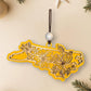 Yellow North Carolina dogwood ornament on a cream background with holiday decorations